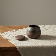 Bodhi mini urn, bruin keramiek met horizontale strepen, ronde vorm, deksel ernaast