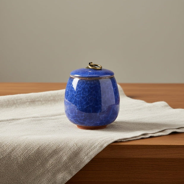 Donkerblauwe keramische urn met craquelé glazuur en bronzen ring, ronde vorm