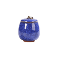Keramische donkerblauwe urn met craquelépatroon en bronzen ring op de deksel, bolle vorm