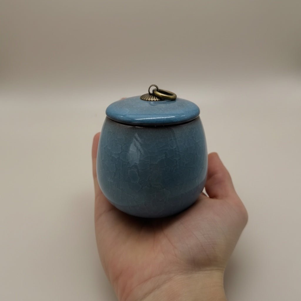 Celeste urn, hemelsblauw, keramiek, ronde vorm, met craquelé en bronzen ring op de deksel