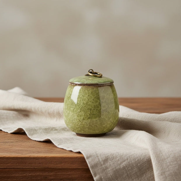 Lichtgroene keramische urn met craquelépatroon, ronde vorm, bronzen ring op de deksel