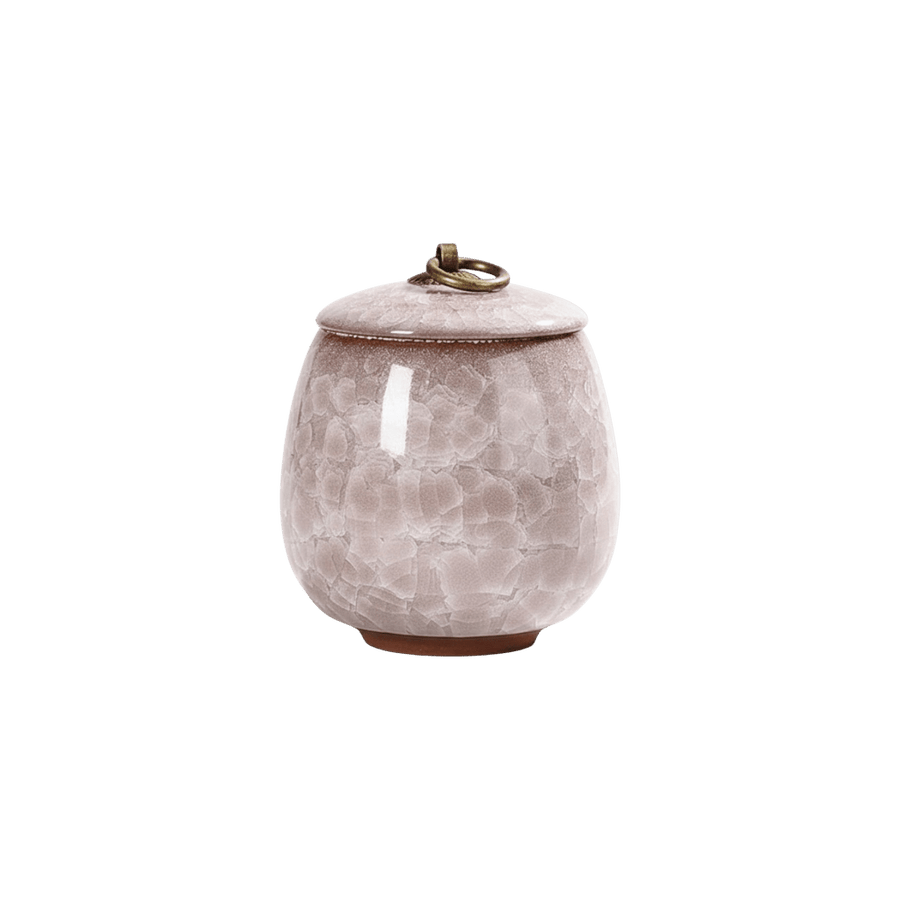 Lichtroze keramische urn met craquelépatroon, ronde vorm, bronzen ring op de deksel