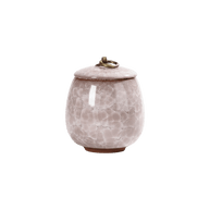 Lichtroze keramische urn met craquelépatroon, ronde vorm, bronzen ring op de deksel