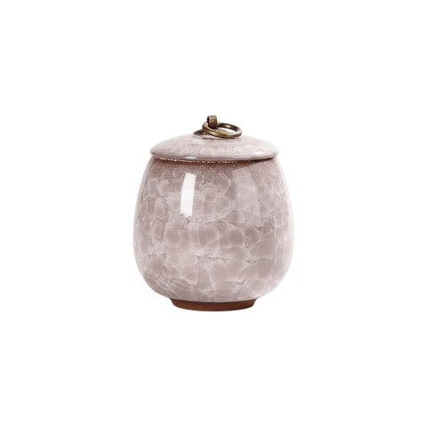 Lichtroze keramische urn met craquelépatroon, ronde vorm, bronzen ring op de deksel