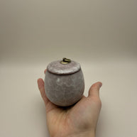 Lichtroze keramische urn met gemarmerd patroon, ronde vorm, bronzen ring op deksel