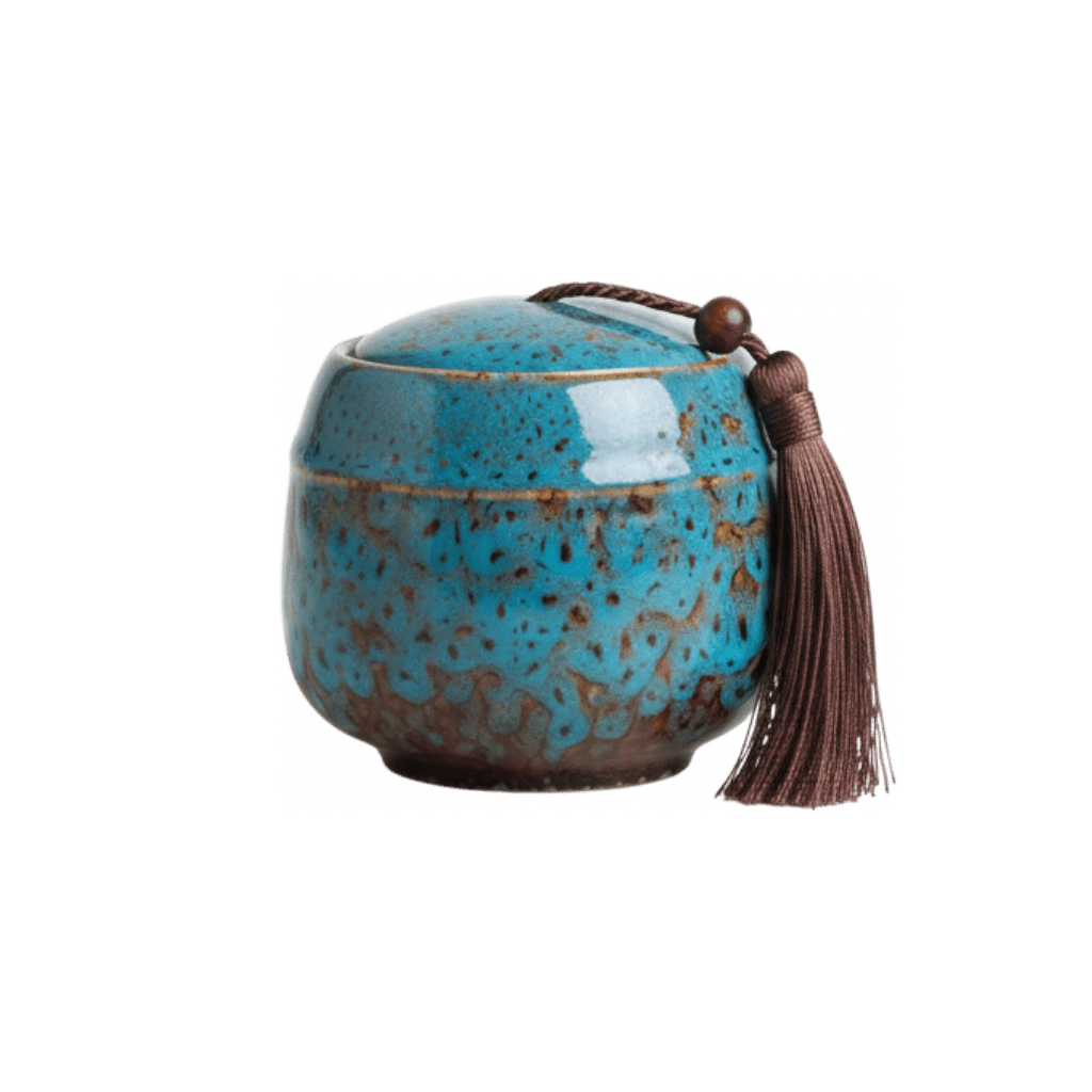 Keramische blauw-bruine urn met gespikkeld glazuur, ronde vorm, met bruine kwast