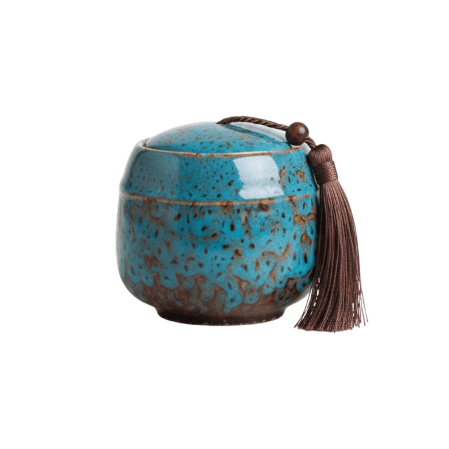 Keramische blauw-bruine urn met gespikkeld glazuur, ronde vorm, met bruine kwast