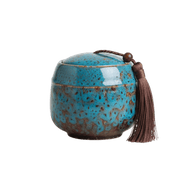 Keramische blauw-bruine urn met gespikkeld glazuur, ronde vorm, met bruine kwast