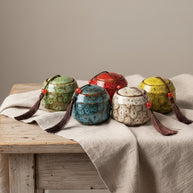 Keramische urnen in groen, blauw, rood, wit en geel met kwastjes, ronde vorm