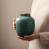 Een persoon houdt een keramische urn vast met beide handen | Izu urn - 2200ML | Artic Urnen